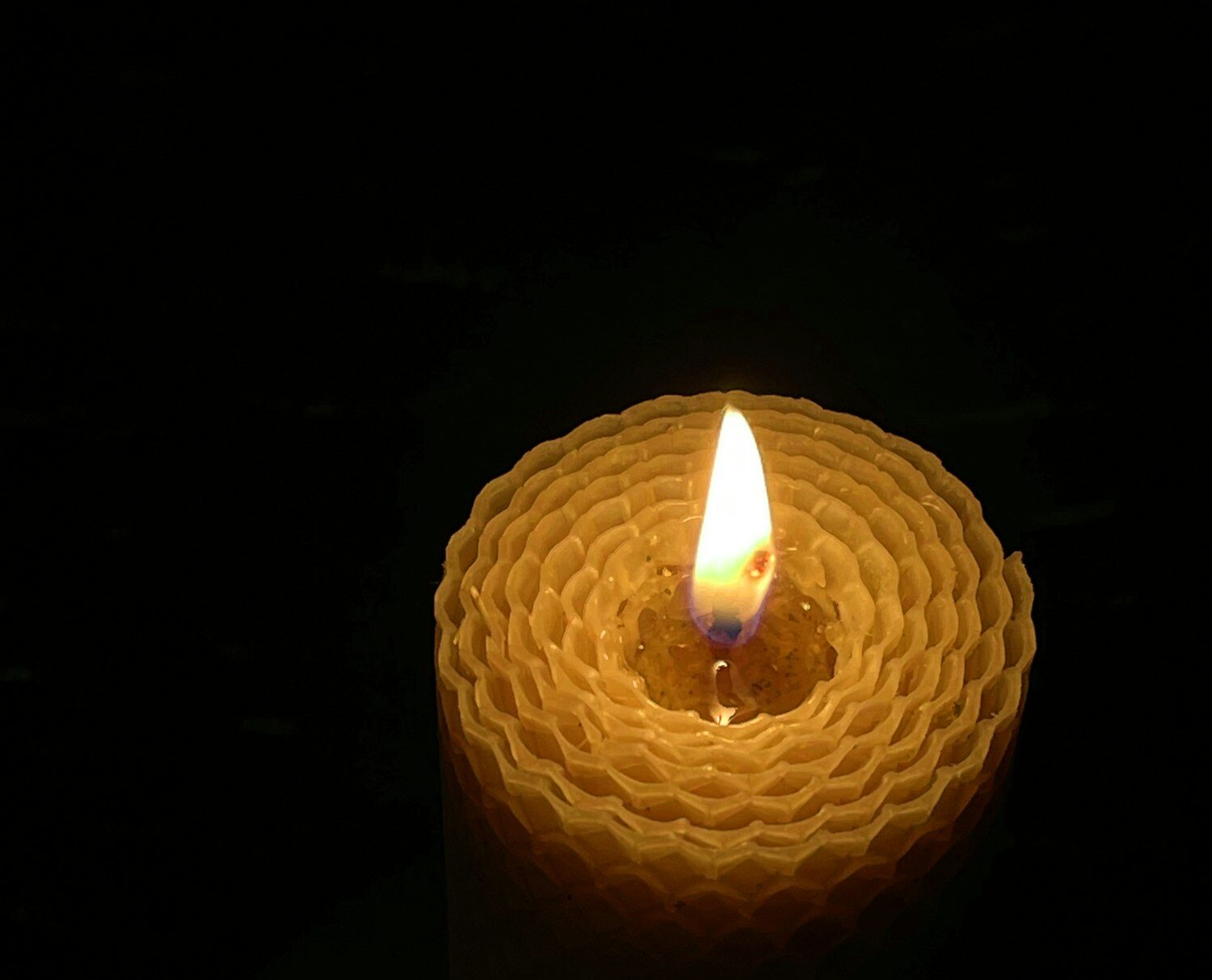 A wax candle burning in the dark