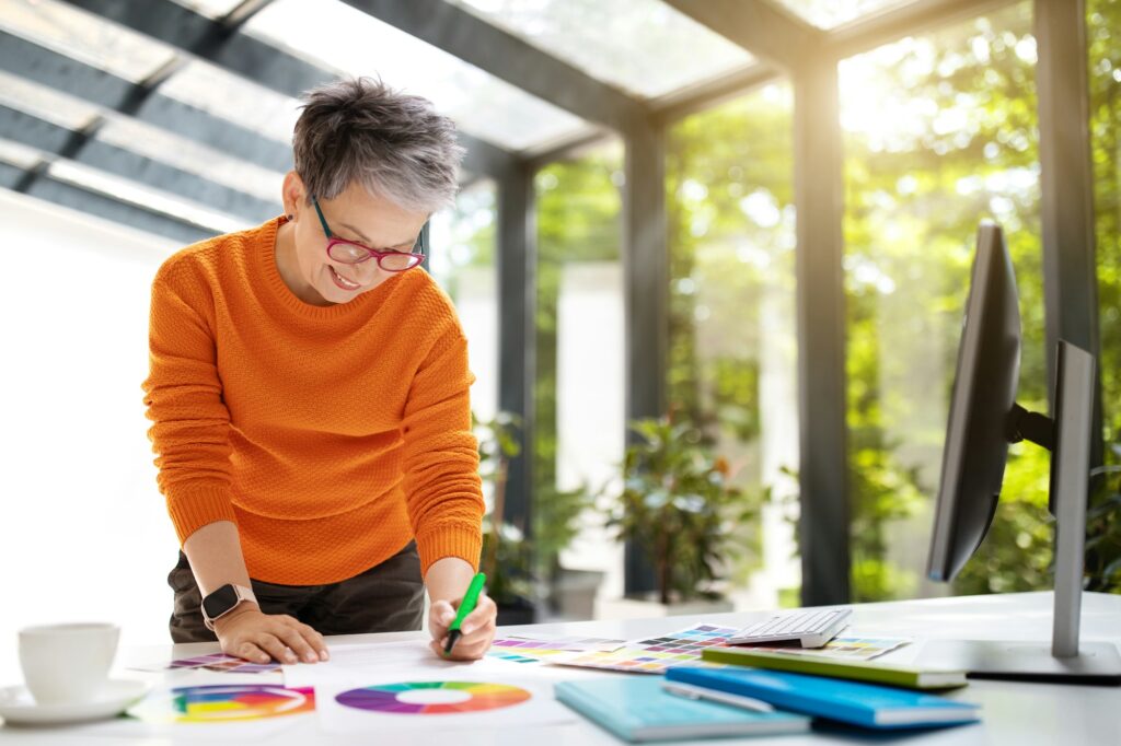 Creative mature woman interior designer working at home office