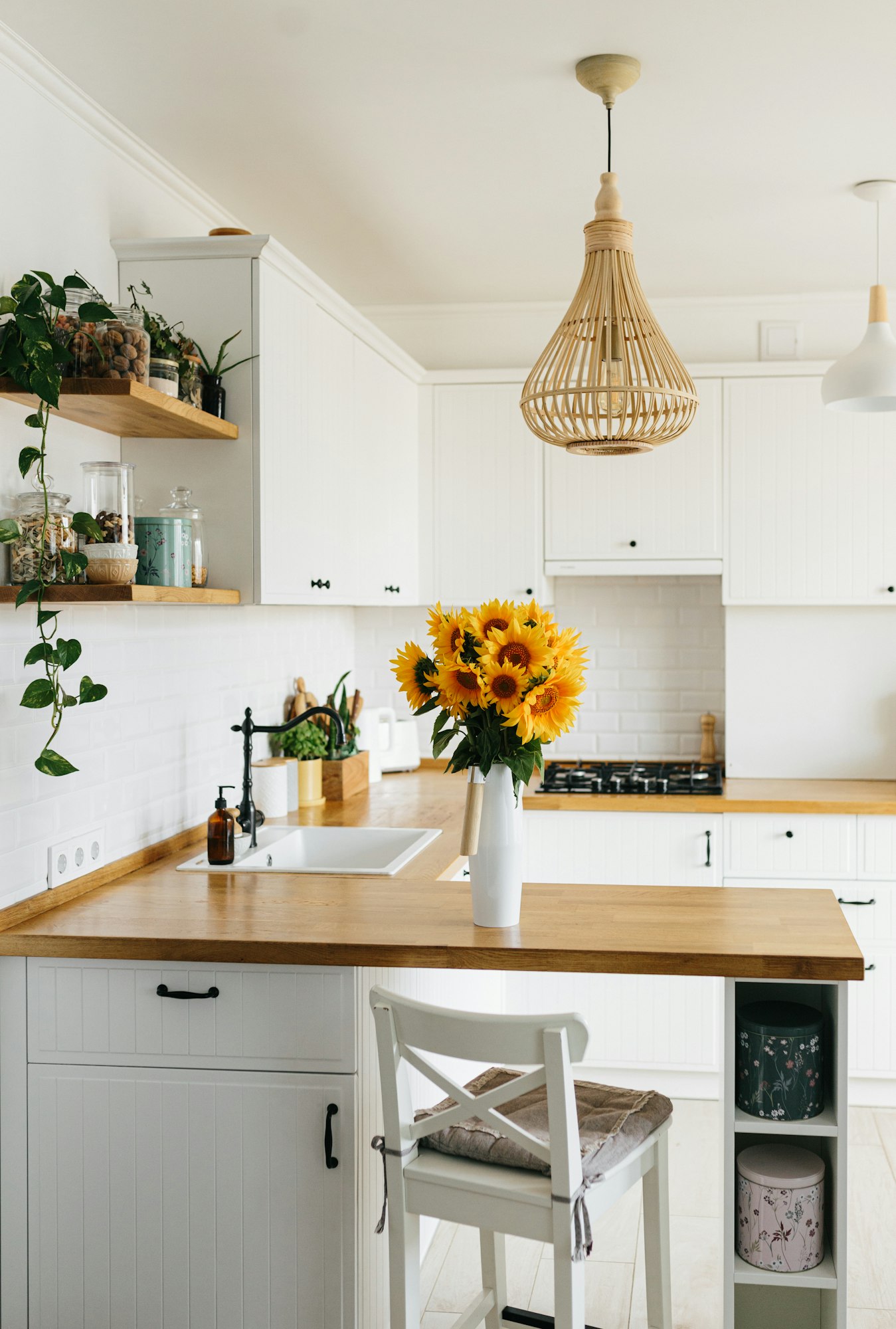 sunflowers bouquet in vase on the kitchen. View on white simple modern kitchen in scandinavian style