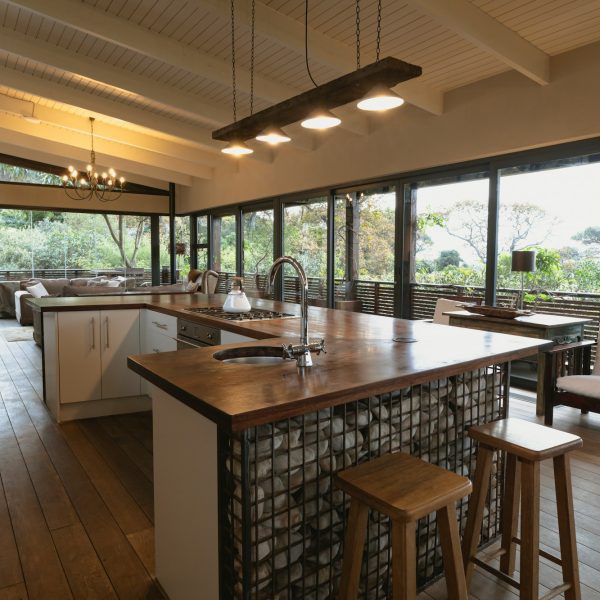 Interior of open plan kitchen diner and living room of comfortable home, with windows to terrace